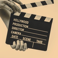 Movie flapper in woman´s hands on white background