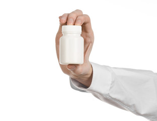 doctor's hand holding a white empty jar of pills studio isolated