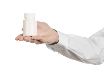 doctor's hand holding a white empty jar of pills studio isolated