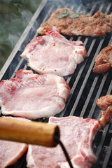 Raw steak cooking on grill 