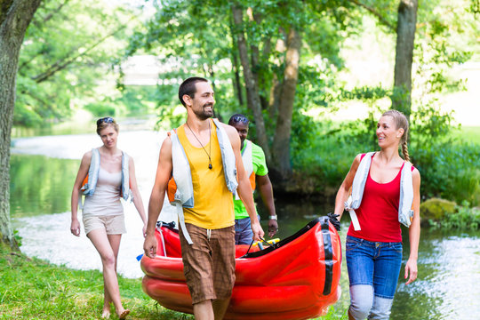 Freunde tragen zusammen Kajak zum Wald Fluss 