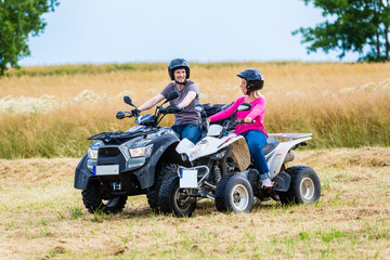 Fototapeta na wymiar Paar fahren Off-Road mit Quad ATV durch Gelände 