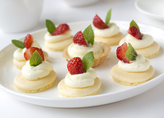 Small biscuits with  strawsberries, whipped cream, mint