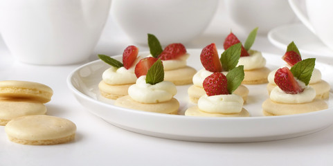Small biscuits with  strawsberries, whipped cream, mint