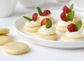 Small biscuits with  strawsberries, whipped cream, mint