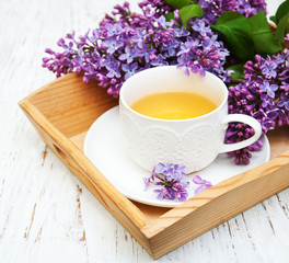 Cup of tea and lilac flowers