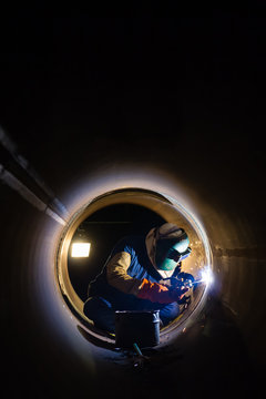 Workers welding work at night in the pipeline.