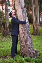Businessman embrace a tree trunk