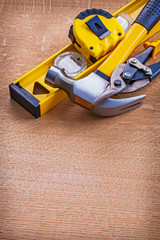 Obraz premium Claw hammer construction level nippers and tape measure on woode