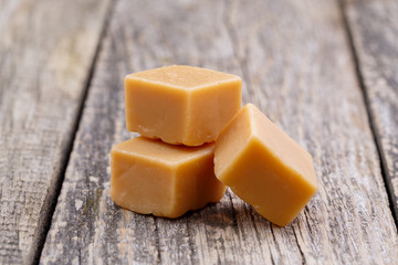 Tasty toffees on wooden background.