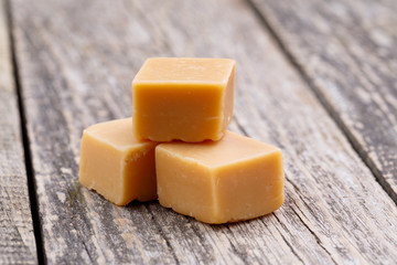 Tasty toffees on wooden background.