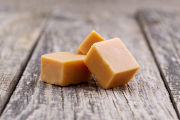 Tasty toffees on wooden background.