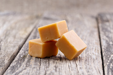 Tasty toffees on wooden background.