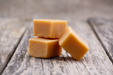 Tasty toffees on wooden background.