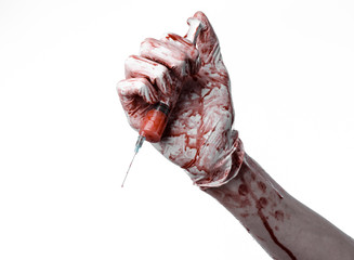 bloody hands of the doctor holding a bloody syringe