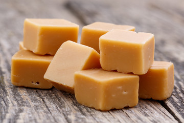 Tasty toffees on wooden background.