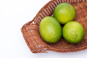 tre lime in un cestino su sfondo bianco © Marco