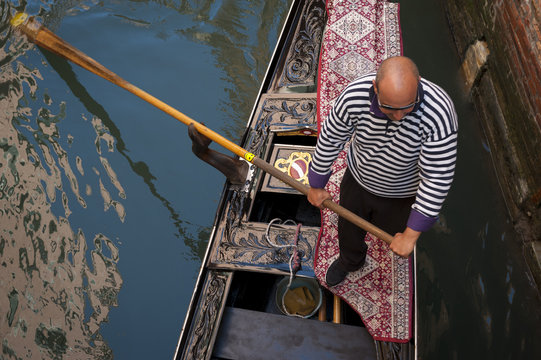 Gondolier Pushing Gondola Passengers in Venice, Italy