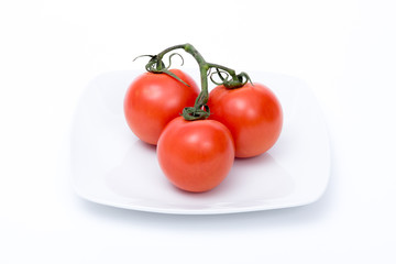 grappolo di pomodori rossi su piatto bianco