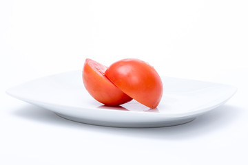 pomodoro tagliato a metà su piatto bianco © Marco