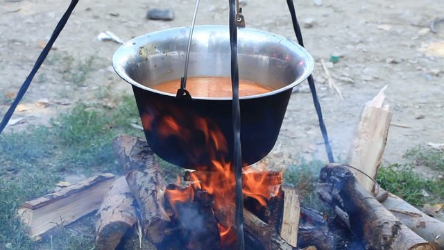Traditional cooking - Fish stew boiling on firewoods