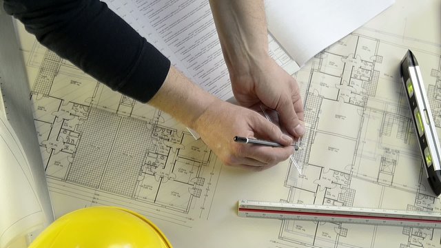an architect while drawing adjustments in a project of a house