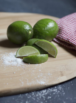 Limes with salt on cutting board