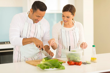 Obraz na płótnie Canvas woman teaching husband cutting vegetables