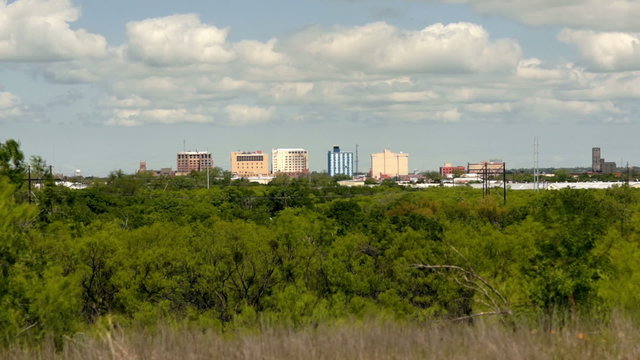 Wind blows the vegetation and clouds over downtown Wichita Falls