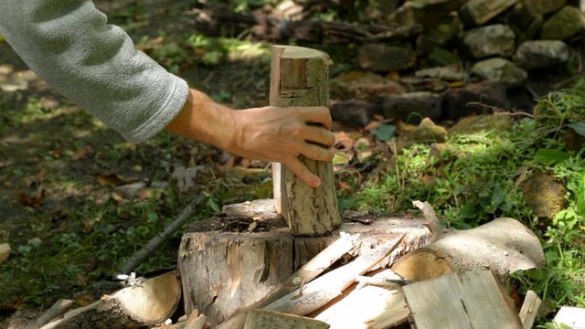 Man carving fire wood using axe