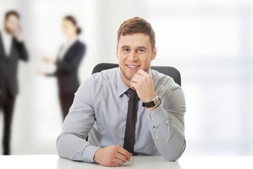 Businessman sitting by a desk in the office.