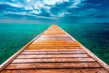 Empty Wooden Dock Over Vibrant Tropical Blue Water - obrazy, fototapety, plakaty