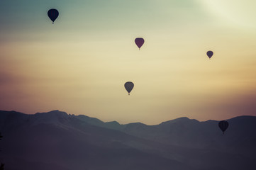 Gruppo di mongolfiere in volo nel cielo al tramonto