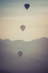 Gruppo di mongolfiere in volo nel cielo al tramonto
