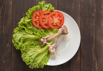 Bone chicken and vegetable on wooden background.