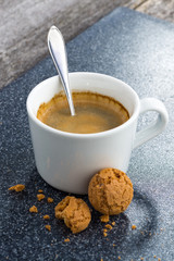 cup of coffee and almond biscuits on a dark background, vertical