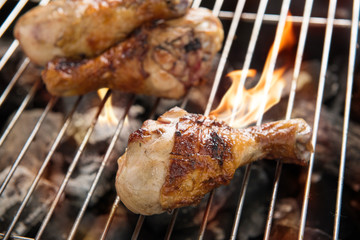 Grilled chicken thigh over flames on a barbecue