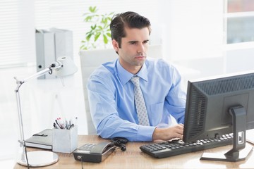 Concentrated businessman typing on the keyboard