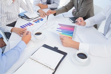Business team analyzing bar chart graphs  