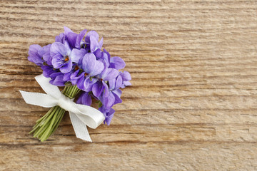 Bouquet of violet flowers (Viola Odorata) on wood