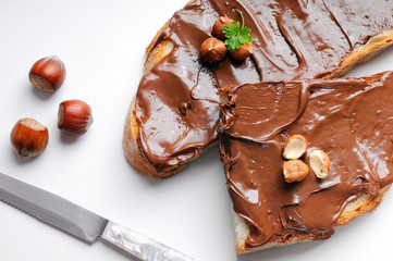 Two slices of bread with chocolate cream and hazelnuts