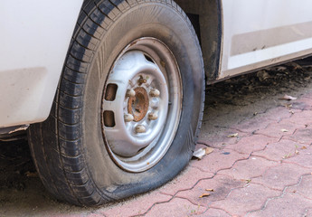 Deflated damaged tyre on car wheel
