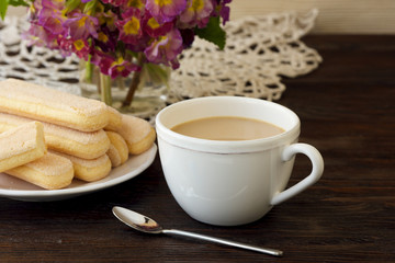 Savoiardi cookies with a cup of coffee on wooden background