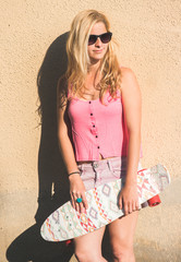 Blonde skateboarder woman posing outdoor