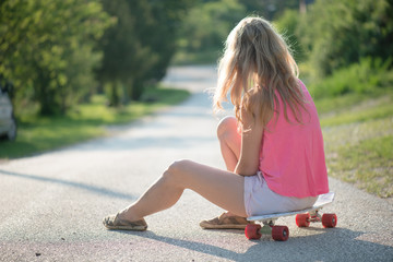 Blonde skateboarder woman resting outdoor