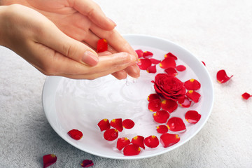 Female hands with bowl of aroma spa water on table, closeup