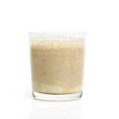 Glass with banana smoothie isolated on white background