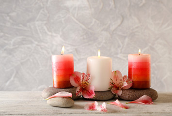 Still life with spa candles on light wallpaper background