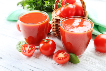 Glasses of fresh tomato juice on wooden table, closeup