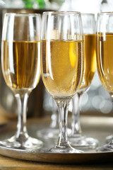 Glasses of champagne on bright background